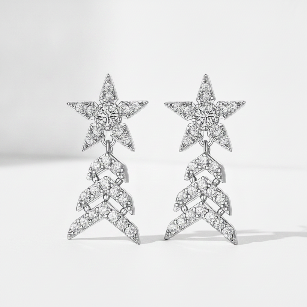 A pair of silver-toned drop earrings featuring a star-shaped top pavé set with clear stones, connected to a chevron-patterned dangling section also paved with clear stones, shown on a light gray background.
